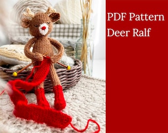 May include: A knitted deer toy wearing red knitted boots and holding red yarn with knitting needles. The deer is sitting on a beige knitted surface. The text "PDF Pattern Deer Ralf" is in the background.