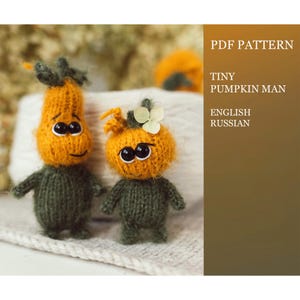 May include: Two handmade, knitted pumpkin figures with orange heads and green bodies. The figures have black eyes and are posed on a white surface. The image also includes text that reads "PDF PATTERN" and "TINY PUMPKIN MAN".