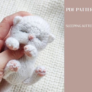 A cute fluffy kitten sleeps in my hand. You can knit the same according to my pattern.