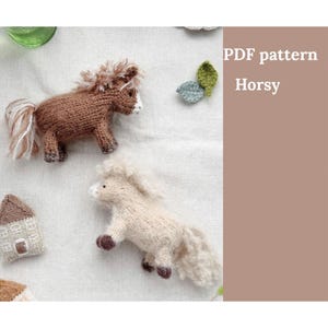 May include: Two knitted toy horses, one brown and one cream, with fluffy manes and tails, are displayed on a white surface. The text "PDF pattern Horsy" is visible. Additional small knitted items, including a house and leaves, are also present.