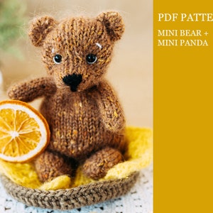 May include: A brown knitted teddy bear sitting in a yellow and brown crocheted basket. The bear has black eyes and a black nose. The text "PDF PATTERN MINI BEAR + MINI PANDA" is in the upper right corner of the image.