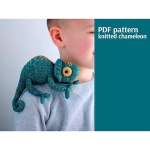 May include: A knitted chameleon toy in shades of teal and yellow, perched on a person's shoulder. The toy has a large eye and is made of yarn. The image includes the text "PDF pattern knitted chameleon."
