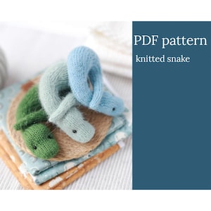 May include: PDF pattern for a knitted snake toy. The pattern includes three snakes in different shades of blue and green.