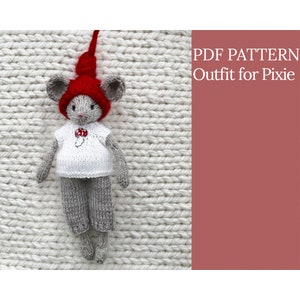 Puede incluir: Patrón PDF para un atuendo tejido para una muñeca de ratón Pixie. El atuendo incluye un gorro rojo, una camisa blanca con un diseño de hongo y pantalones grises.