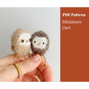 Op de afbeelding: Twee miniatuur gebreide uilen, een bruin en een beige, met witte gezichten en zwarte ogen. De uilen worden vastgehouden in een hand met een gouden ring. De tekst "PDF Pattern Miniature Owl" is op de achtergrond.
