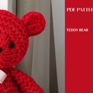 Könnte beinhalten: Ein roter gestrickter Teddybär mit schwarzen Augen und einer weißen Schleife. Der Bär sitzt auf einer weißen Oberfläche. Das Bild ist mit "PDF PATTERN TEDDY BEAR" beschriftet.