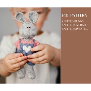 Pode incluir: Um brinquedo de coelho cinza tricotado com orelhas compridas, usando macacão azul com um coração branco e uma camisa rosa. O texto à direita diz "PDF PATTERN" e lista os itens incluídos no padrão.