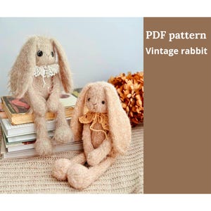 Puede incluir: Dos conejos de peluche hechos a mano, con orejas largas y extremidades flexibles. Uno de los conejos lleva un cuello de encaje blanco, el otro un cuello de ganchillo amarillo. El texto "PDF pattern Vintage rabbit" es visible a la derecha.