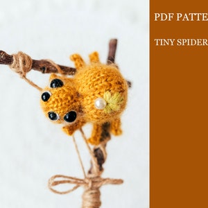 May include: A crochet pattern for a tiny spider, with the words "PDF PATTERN TINY SPIDER" in the upper right corner of the image.