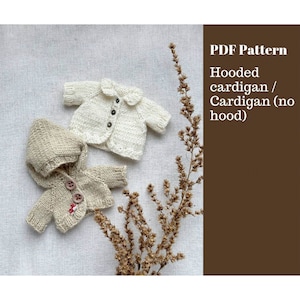 May include: Two knitted baby cardigans, one with a hood and one without. The cardigan without a hood has a white collar. Both cardigans have buttons. PDF Pattern Hooded cardigan / Cardigan (no hood)