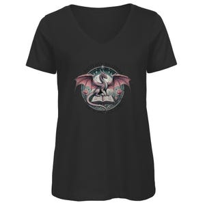 Könnte beinhalten: Schwarzes V-Ausschnitt-T-Shirt mit einem Grafikdruck eines rosa Drachen, der ein Buch offen hält. Der Text um den Drachen lautet "Fantasy Readers Are The Best Kind Of People".