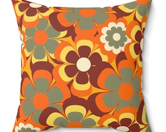 May include: A throw pillow with a retro floral pattern in shades of orange, yellow, brown, and green. The pillow features a repeating design of stylized flowers with rounded petals.