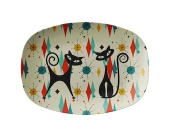 May include: A white oval serving platter with a retro pattern of black cats, red, blue, and yellow diamonds, and yellow stars.