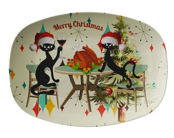 May include: A white oval platter with a retro Christmas design featuring two black cats wearing Santa hats, a Christmas tree, and a roasted turkey on a table. The text "Merry Christmas" is printed on the platter.