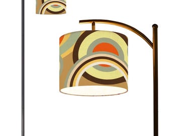 May include: A black floor lamp with a curved arm and a beige, brown, and orange patterned lampshade. The lampshade has a geometric design with circles and arcs.