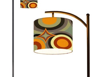 May include: A black floor lamp with a curved arm and a white and orange patterned lampshade. The lampshade has a geometric design with circles and stars.