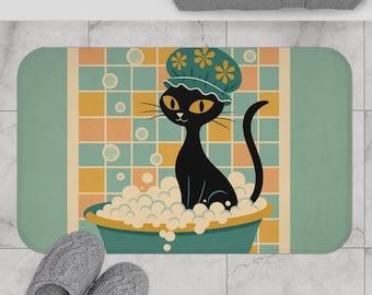 Peut inclure: Tapis de bain rectangulaire avec un chat noir de dessin animé portant un bonnet de douche à fleurs, dans une baignoire pleine de bulles. Le fond présente un motif de carreaux rétro en bleu sarcelle, orange et jaune. Des pantoufles grises sont en bas.