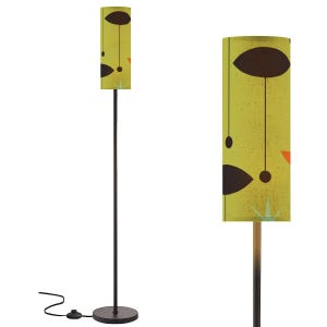 May include: A mid-century modern floor lamp with a cylindrical shade. The shade features a yellow-green background with a repeating pattern of brown teardrop shapes, orange triangles, and starbursts. The lamp has a black metal pole and base.