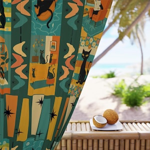 May include: A patterned curtain with a mid-century modern design. It features black cat illustrations, starbursts, and boomerang shapes in teal, orange, and yellow. The curtain hangs in front of a tropical beach scene with coconuts on a bamboo table.