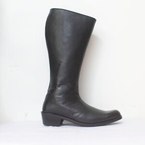 May include: A pair of black leather knee-high boots with a low heel.