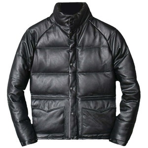 Puede incluir: Una chaqueta acolchada de cuero negro con cierre de botones a presión y dos bolsillos delanteros.