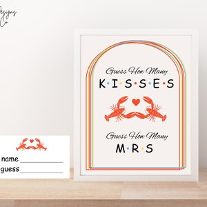 May include: Printable game card with a colorful rainbow arch design. The card says "Guess How Many Kisses" and "Guess How Many Mrs" with a lobster illustration.
