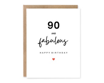 Peut inclure: Carte d'anniversaire blanche avec une enveloppe marron. Le texte "90 and fabulous" est écrit en noir, avec "Happy Birthday" en dessous. Un petit cœur rouge est en bas.