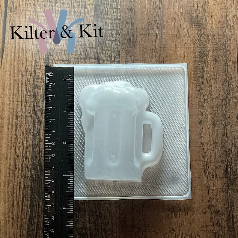 Może przedstawiać: Przezroczysta plastikowa forma do robienia kufla piwa. Forma ma około 7,6 cm wysokości i 5 cm szerokości.