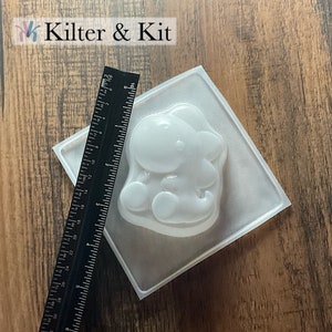 May include: A clear plastic mold for making a small dinosaur-shaped object. The mold is approximately 3 inches wide and 3 inches long.