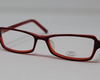 May include: Red plastic framed eyeglasses with clear lenses. The brand name "STEVE MADDEN" is printed on the right lens.