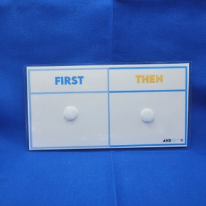 May include: White board with the words "FIRST" and "THEN" written in blue. There are two white circles on the board.