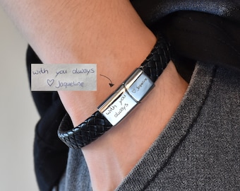 May include: Black leather bracelet with a silver clasp engraved with the words "with you always" and a heart symbol followed by "Jacqueline".