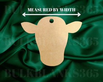 May include: A brown wooden cow cutout with a hole at the top. The cutout is on a green fabric background. The text "MEASURED BY WIDTH" is above the cutout.