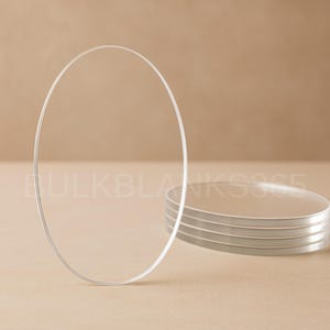 May include: Clear, oval-shaped glass blanks, stacked and standing upright. The image shows a stack of several clear glass blanks, with one standing upright. The text "BULKBLANKS365" is visible in the background.