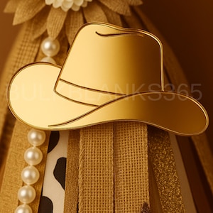 May include: A gold-colored cowboy hat-shaped decoration. The hat is reflective and has a curved brim and a band around the crown. The decoration is placed on a burlap and pearl-adorned background. The text "BULKBLANKS365" is visible.