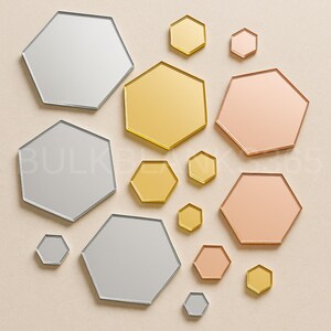 May include: An assortment of hexagon-shaped mirrors in various sizes and metallic finishes, including silver, gold, and rose gold. The mirrors are arranged on a neutral background, creating a modern and geometric aesthetic.