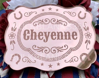 May include: A rose gold mirrored acrylic plaque with a scalloped edge, featuring the name Cheyenne engraved in the center. The design includes a rope border, four horseshoes, stars, and floral accents, with the text BULKBLANKS365 visible.