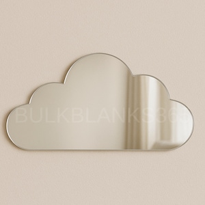 May include: Cloud-shaped mirror with a reflective surface. The mirror has a smooth, rounded edge and is mounted on a neutral-colored wall. The text "BULKBLANK360" is faintly visible across the mirror's surface.