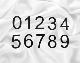 May include: Black numbers 0 through 9 on a white fabric background.