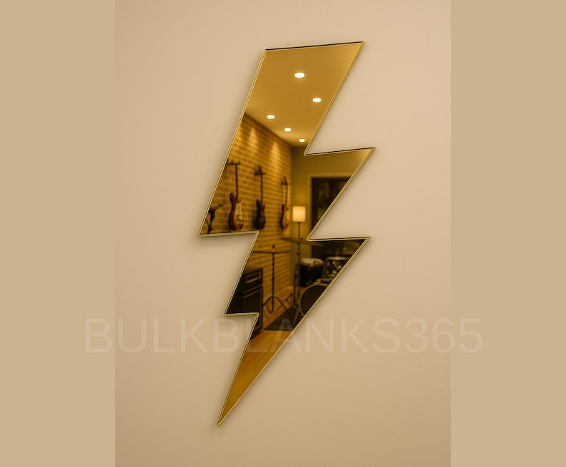 May include: A gold-colored, lightning bolt-shaped mirror mounted on a beige wall. The mirror reflects a room with musical instruments and a brick wall. The text "BULKBLANKS365" is visible at the bottom.