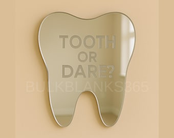 May include: A tooth-shaped mirror with the words "TOOTH OR DARE?" etched into the reflective surface. The mirror has a silver finish and is mounted on a light beige wall. The overall design is playful and dental-themed.