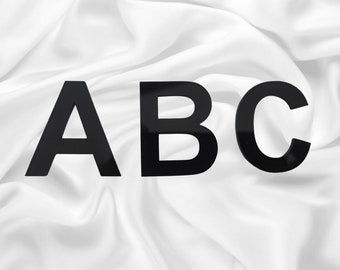 May include: Black letters A, B, and C on a white fabric background.