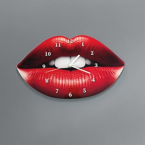 Può includere: Orologio da parete a forma di labbra rosse con numeri e lancette bianchi. Il quadrante dell'orologio è un primo piano di una coppia di labbra con denti bianchi.