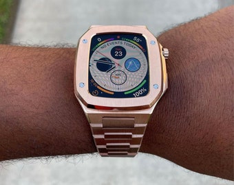 以下が含まれることがあります： 正方形の文字盤と金属製のバンドが付いた、ローズゴールドのApple Watch。時計の文字盤には、時間、日付、天気情報が表示されています。時計の文字盤のテキストには、「NO EVENTS TODAY」と表示されています。
