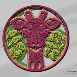 May include: A pink and green layered paper cut design of a giraffe's head with leaves around it. The design is in a circle and has a white background.