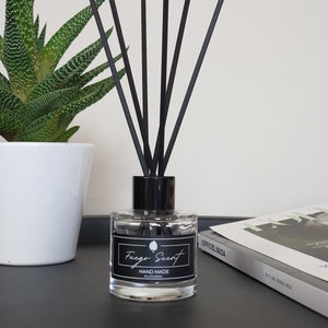 May include: A clear glass bottle with a black lid and black diffuser sticks. The bottle is labelled "Fuego Scent" and "Hand Made in Lithuania".