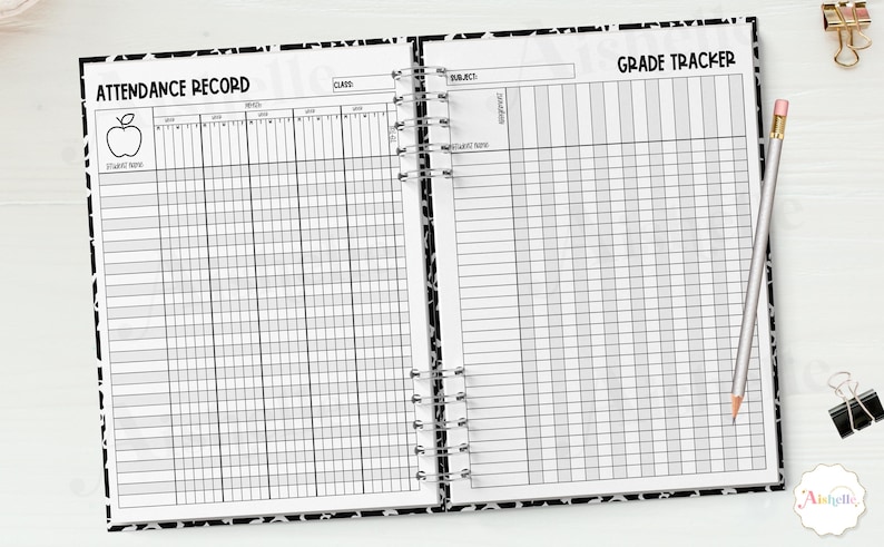 May include: Open notebook with a black and white patterned cover, featuring an attendance record and grade tracker. The left page has an apple graphic. A pencil and binder clips are on the right. The pages are lined for writing.
