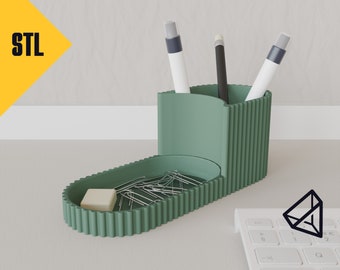 May include: A green desk organizer with a separate compartment for pens and pencils, and a tray for paper clips and an eraser. The organizer has a ribbed design.