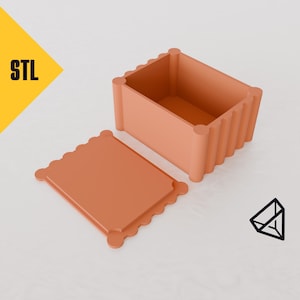 May include: An open, terracotta-colored box with a decorative, scalloped lid. The box is made of a smooth, textured material and has a simple, modern design.