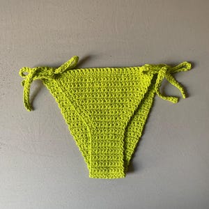 May include: Lime green crochet bikini bottom with ties on each side.